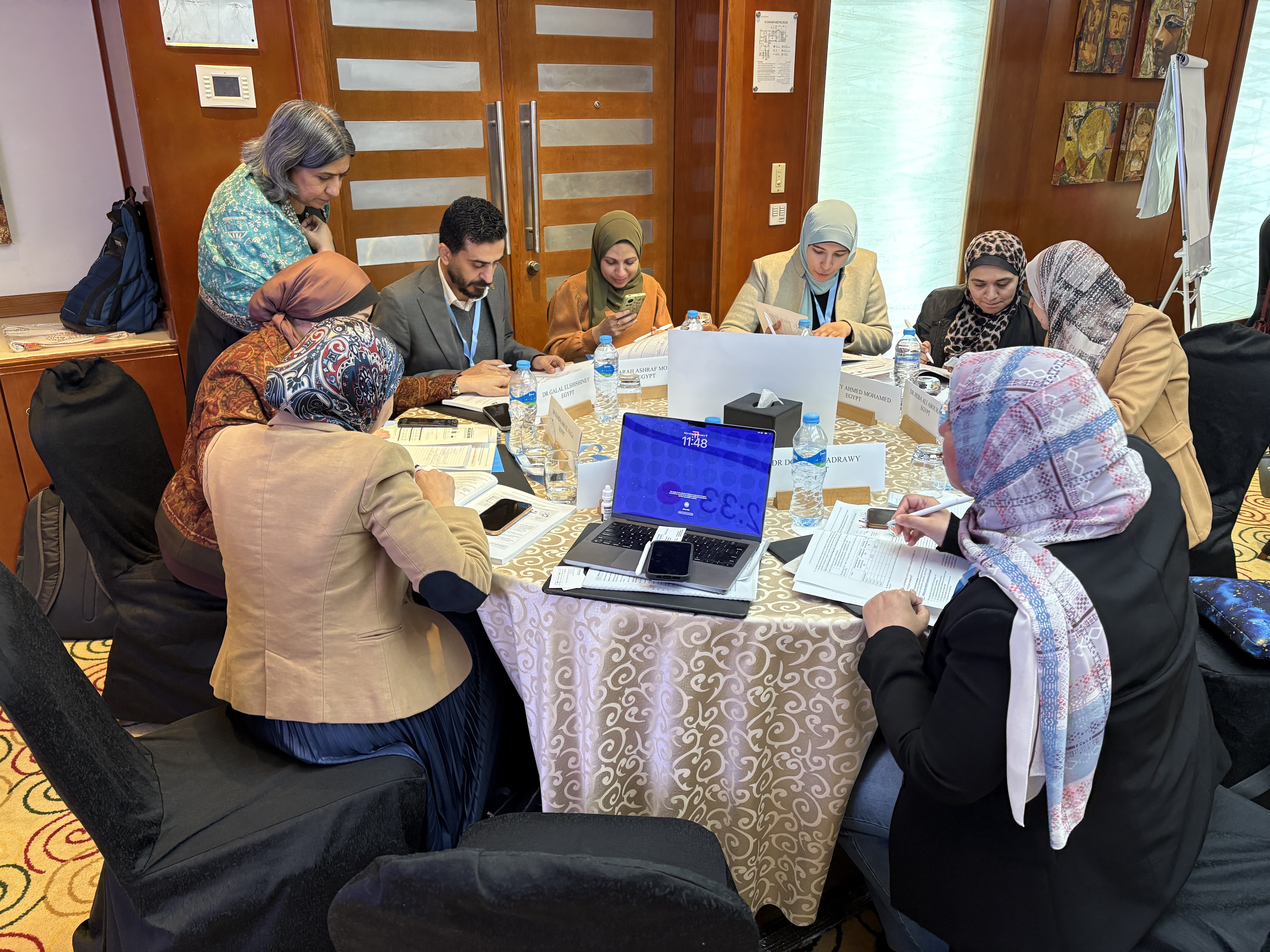 Participants sit at table with program facilitator