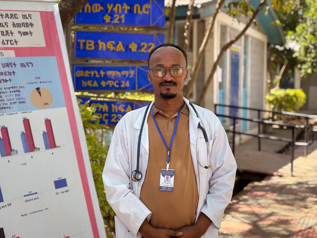 A health care worker stands in front of a clinic in Ethiopia