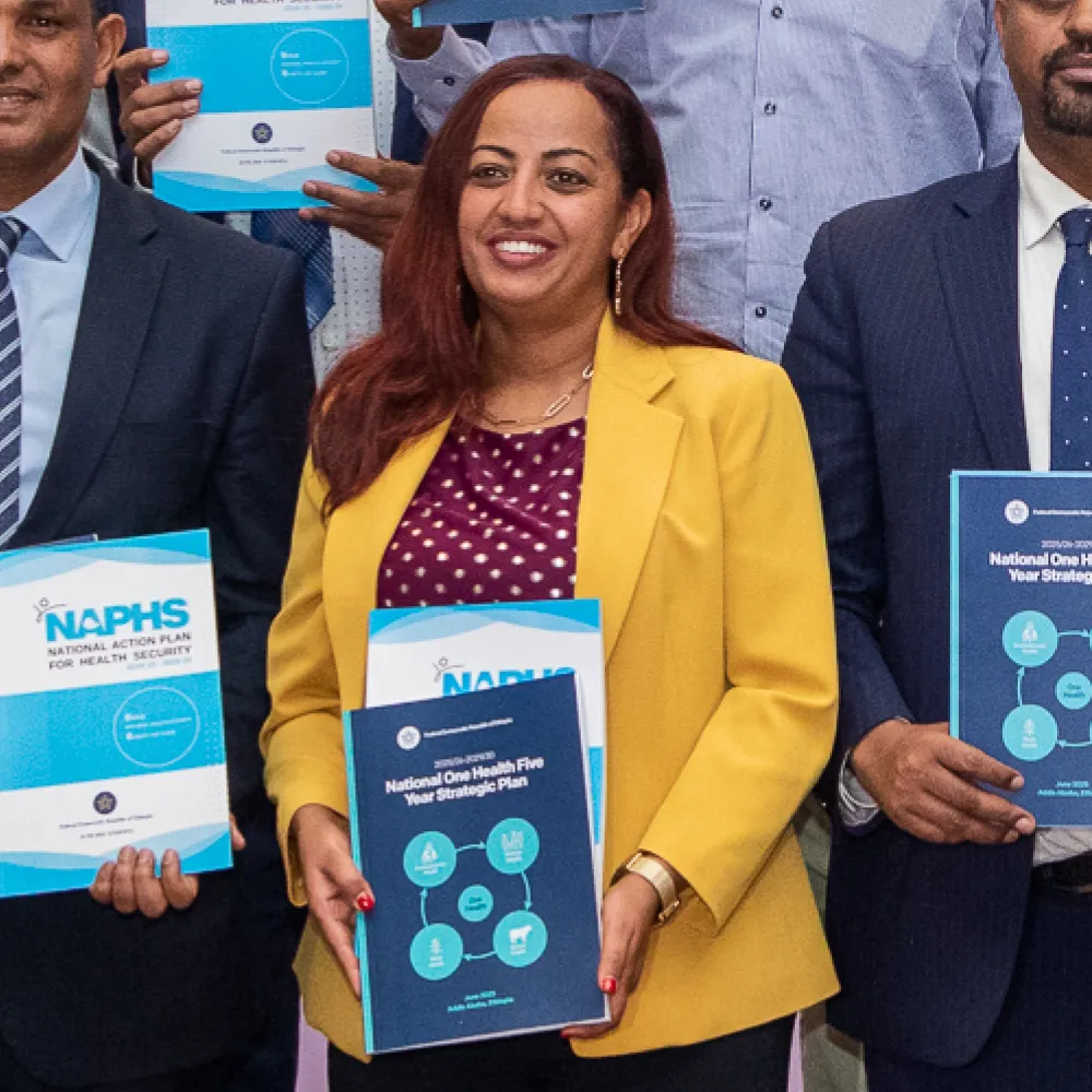 A woman holding a copy of the NAPHS report