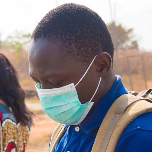 An African health care worker standing outside in a mask
