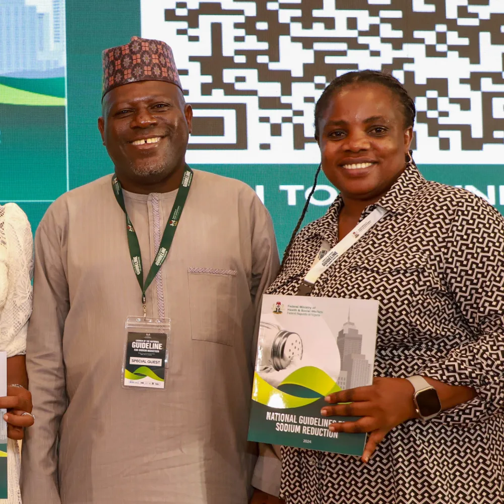A Nigerian man and woman holding up a copy of the sodium report