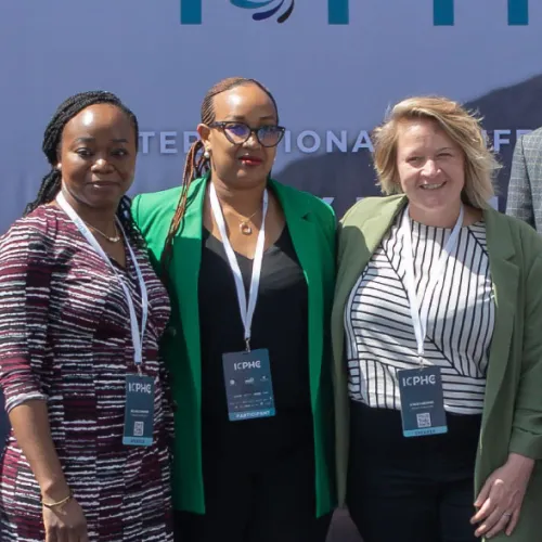 Three female RTSL staff members smiling for a group photo outside the conference
